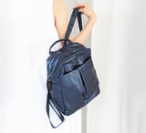 Blue backpack held by a person against a white background