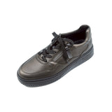 Metallic leather sneaker with black laces on a white background