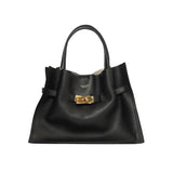 A black leather tote bag with a textured surface, two handles, and a detachable shoulder strap.
