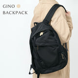 GINO Black backpack worn by a person in a beige coat on a white background
